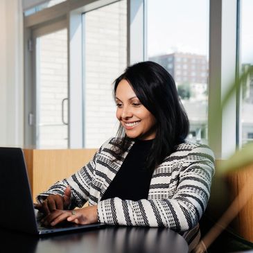 A happy consultant reviewing information on a computer