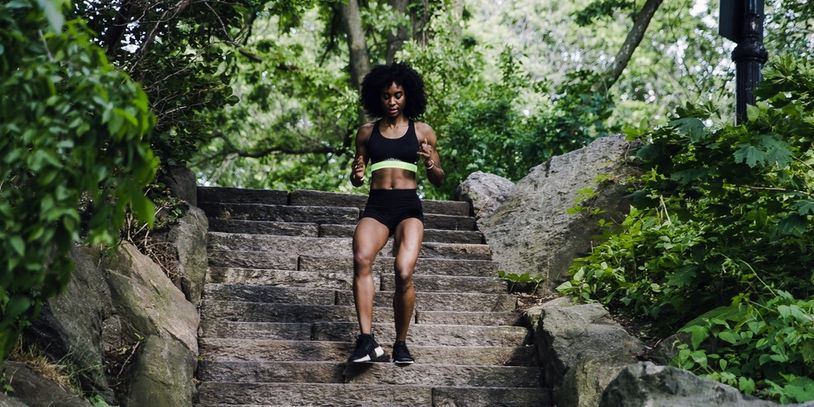 Woman jogging down granite stairs in a wooded area