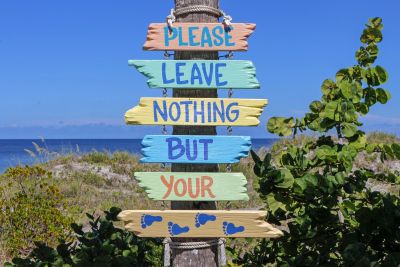 Colorful wooden sign urging visitors to leave no trace but footprints.