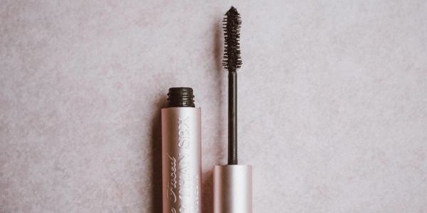 Open mascara tube with a brush.