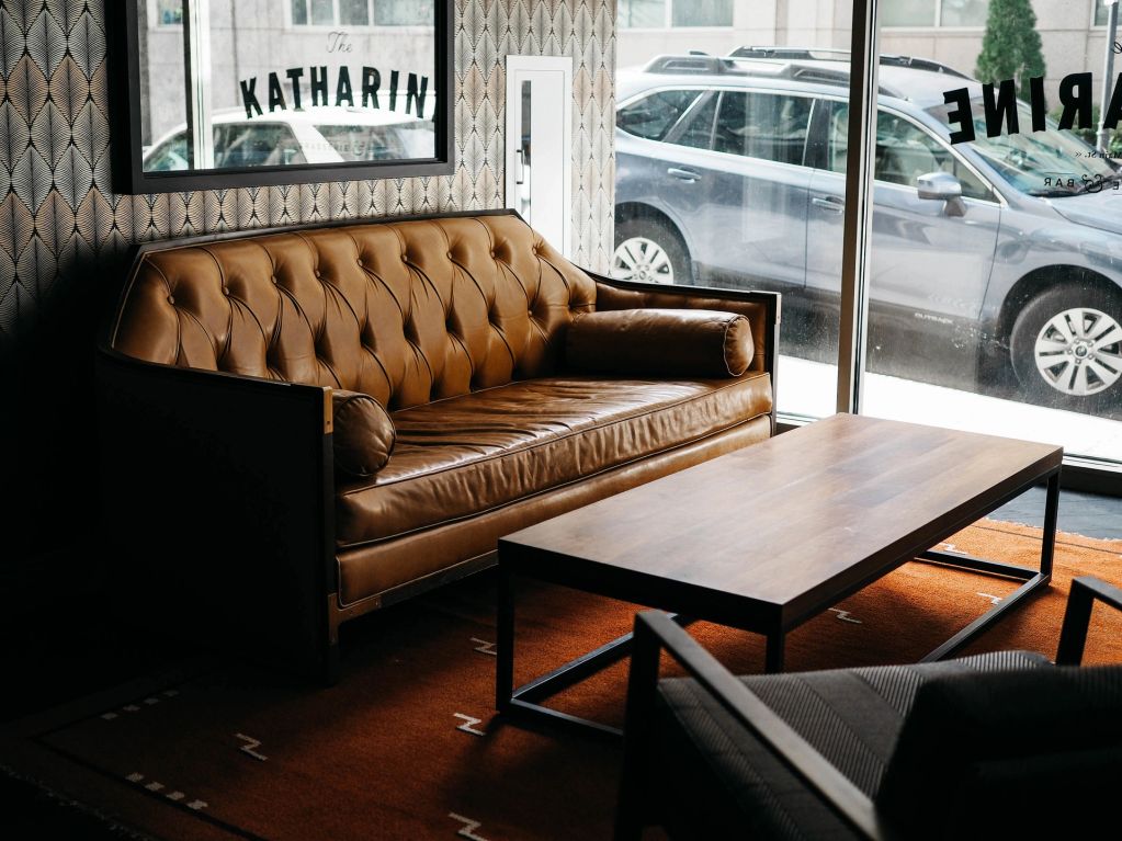 Brown leather sofa with a wooden coffee table in a modern lounge.