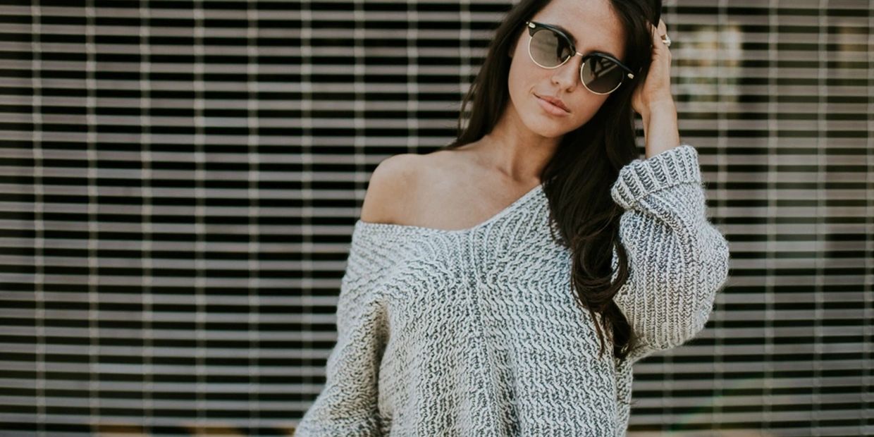 Woman in sunglasses and off-shoulder sweater.