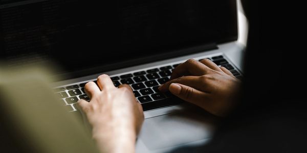 Person typing on a computer keyboard.