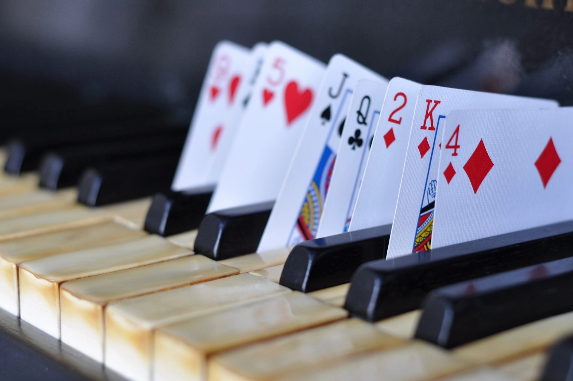 Playing cards arranged on piano keys.