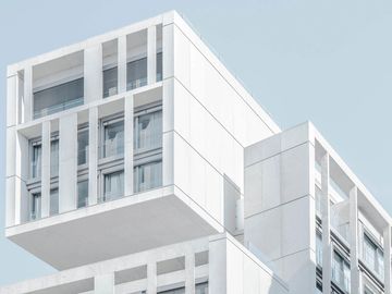 Modern white architectural building with large windows.