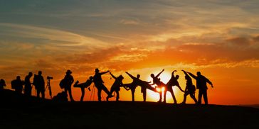 People dancing while the sun is setting.