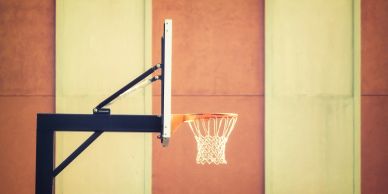 A basketball hoop against a colorful wall.