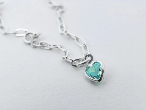 Silver heart necklace with teal stone.