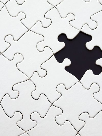 A white puzzleboard with a black missing puzzle piece