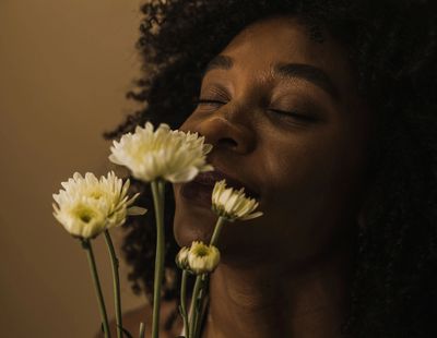 women smelling flowers with eyes closed