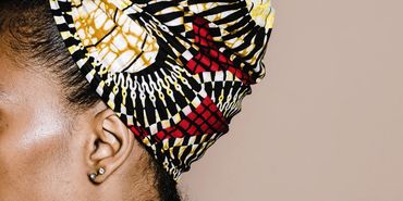 Profile of a woman wearing a colorful headwrap.