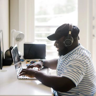Man with headphones on his laptop. RODBT. PACT. Brainspotting. Group therapy. Austin and Texas.