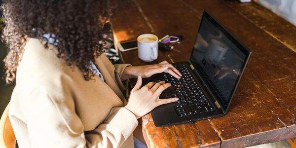 woman at coffee shop working on a laptop