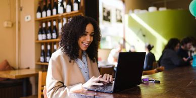 This lady got her new job and she is emailing her friends and family on her laptop. 