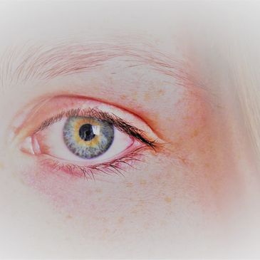 Close-up of a blue-green eye with delicate skin and fine eyelashes.