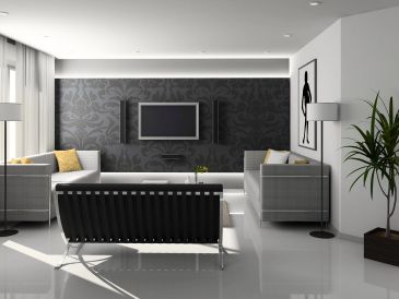 Modern living room with sleek furniture and dark accent wall.
