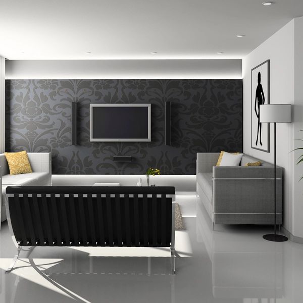 Modern living room with black and gray furniture and a patterned black accent wall.