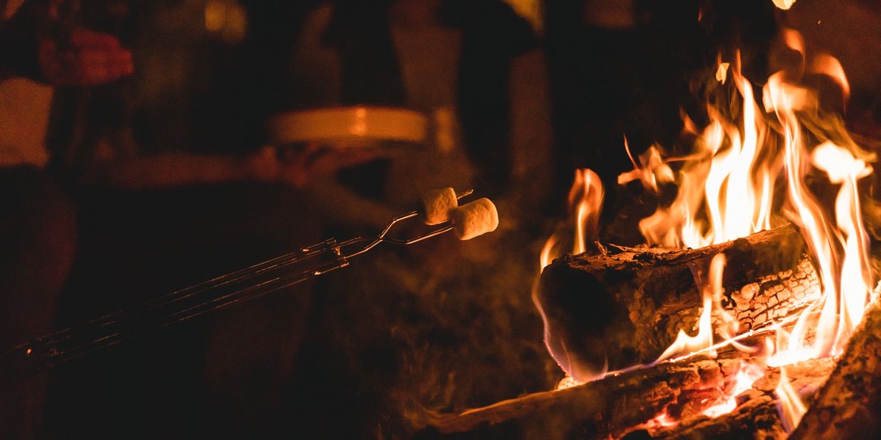 Roasting marshmallows over a campfire.