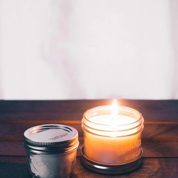 flaming soy wax candle in a glass tin