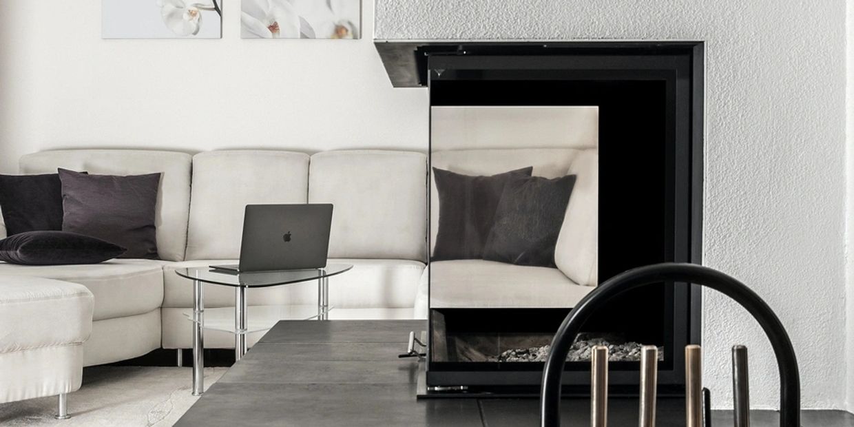 Modern living room with a white sofa and a laptop.