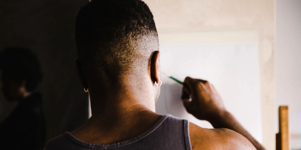 Man painting on a canvas from behind.