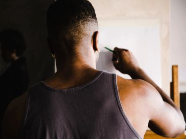 Man painting on canvas with focused attention.