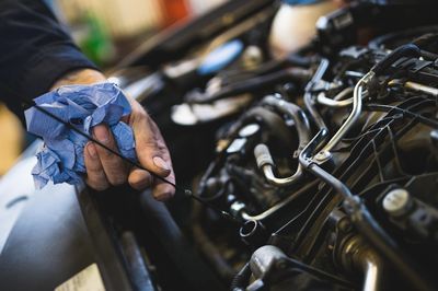 Man checking engine oil dipstick