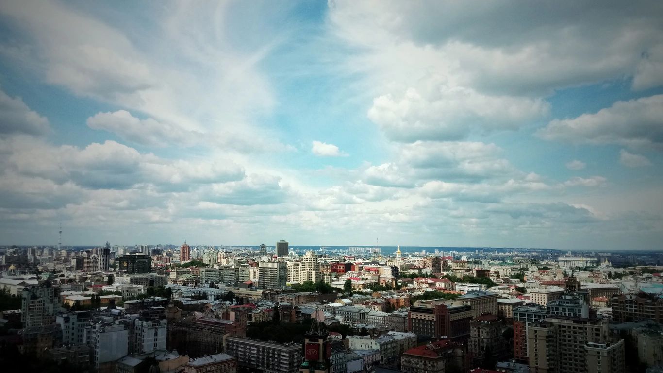 Panoramic cityscape under a partly cloudy sky during daytime.