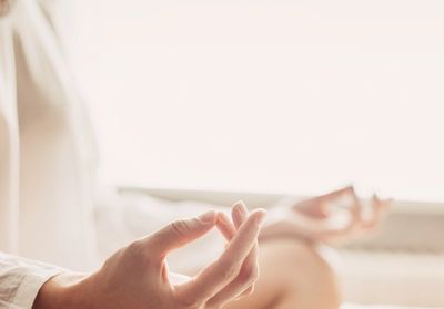 Close-up of hands in meditation pose with soft lighting.