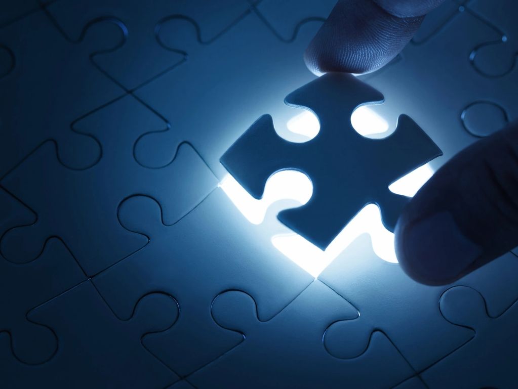 Hand placing the final glowing puzzle piece.