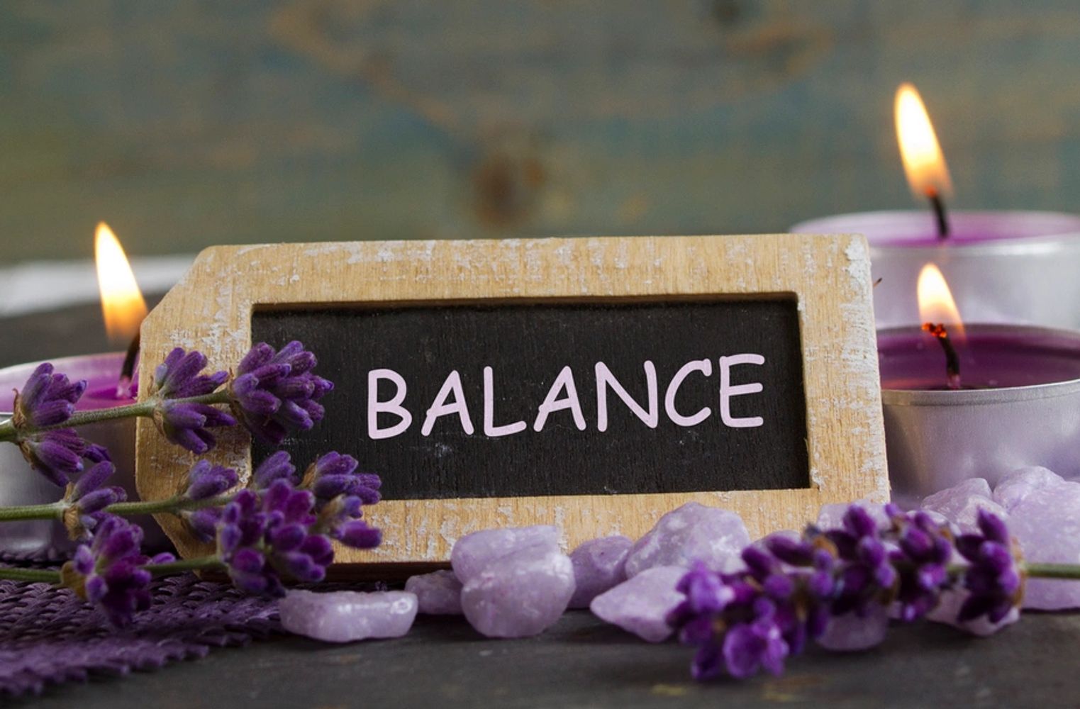 Lavender flowers, candles, and a sign with the word 'BALANCE'.