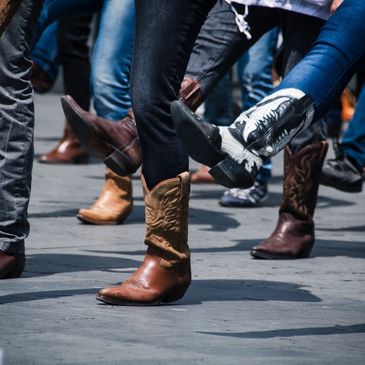 People dancing in cowboy boots and casual shoes.