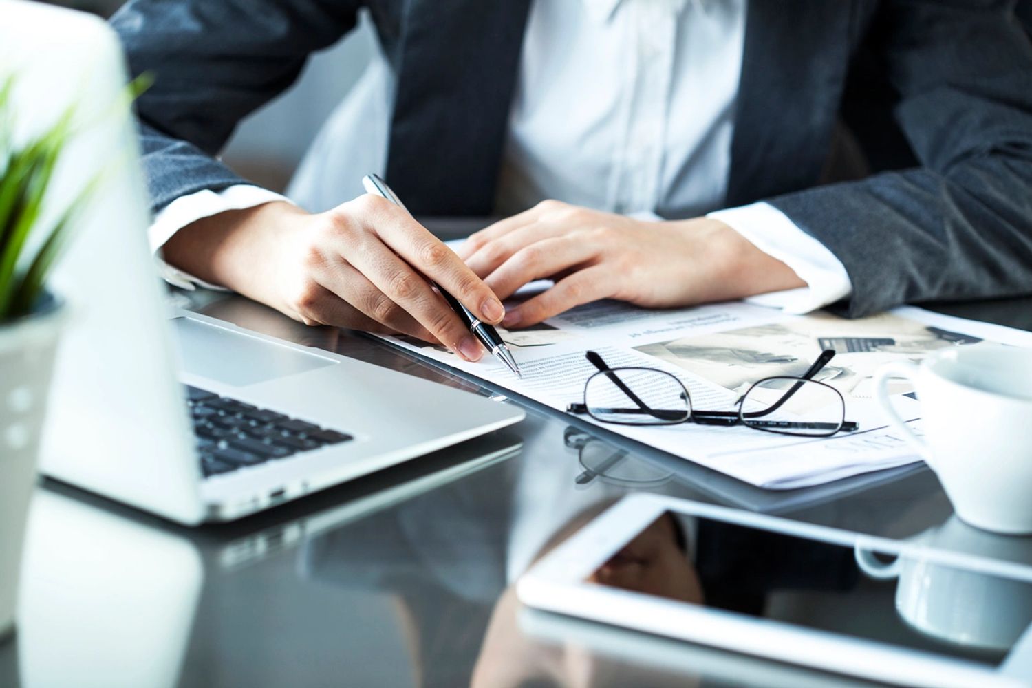 Person sitting at desk in front of computer reviewing a document.