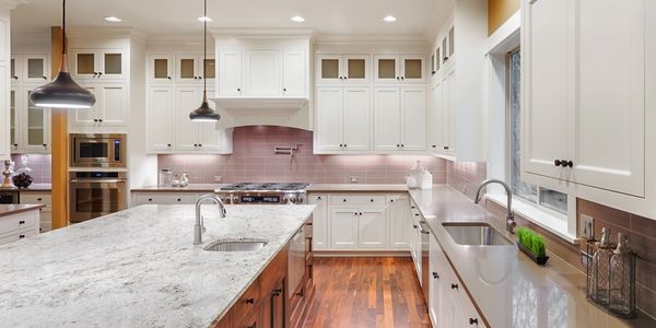 New kitchen with hardwood floors and marble countertops.