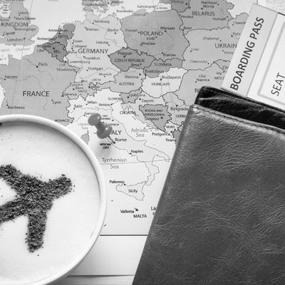 Map of Europe with a coffee cup, wallet, and boarding pass placed on top of it