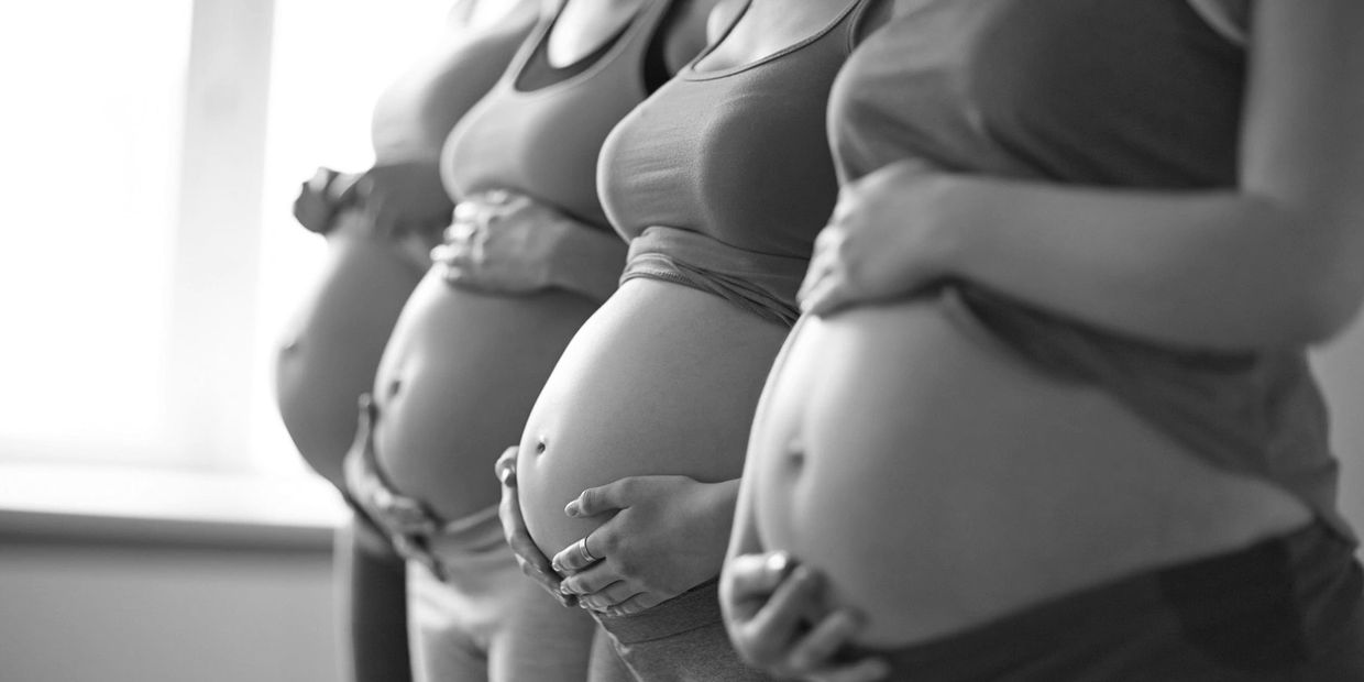 Four pregnant women showing their baby bump during a childbirth education class. Nashville, Doula