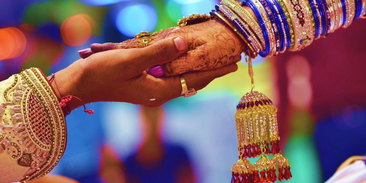 Photograph of bride and groom hands during the wedding ceremony