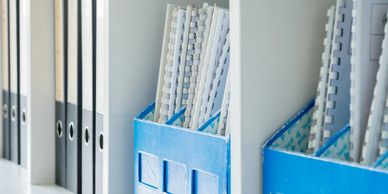 Organized office shelves with binders and document holders.