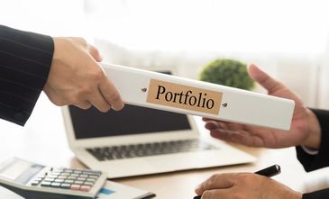 A person handing over a portfolio binder in a professional setting.
