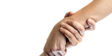 Two hands grasping each other in a supportive gesture.