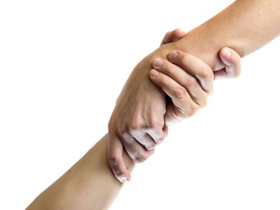 Two hands gripping each other firmly in a supportive gesture.