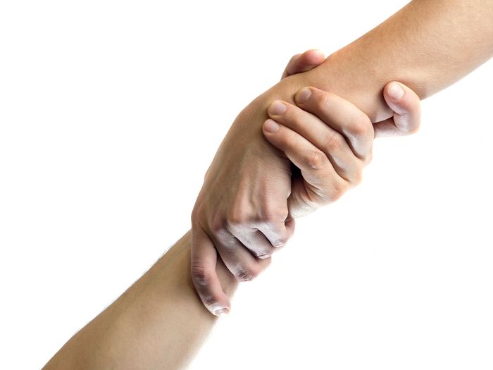 One hand firmly grasping another, symbolizing support and help.