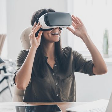 Woman sitting in a chair smiling with a VR headset on