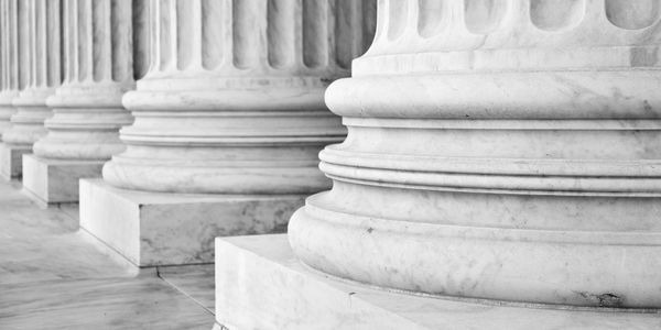 Close-up of classical marble columns with fluted shafts and detailed bases.