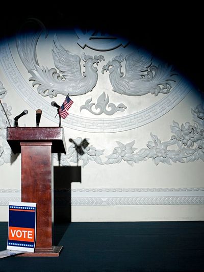Empty podium with microphones and vote sign.