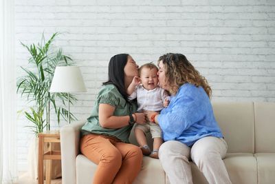 two lesbian moms kissing baby