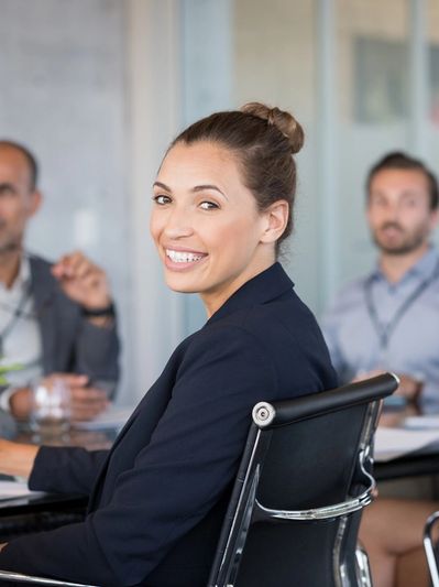 A woman wearing a black blazer while sitting on a meeting