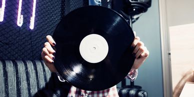 someone holding a record speaker and neon light