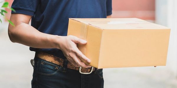a delivery person wearing a blue shirt and holding a package