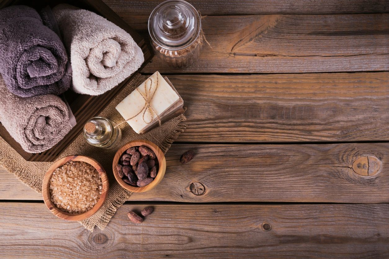 Image of assorted rolled up towels, soap tied up in twine, perfume bottle, raw incense and bath salt